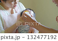 A man and a woman feeding a baby with milk from a baby bottle 132477192