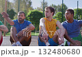 Positive sporty fit diverse multiracial male athletes sitting on outdoor basketball courts friendly talking and sharing while streetball players relaxing after game. Positive sporty fit diverse multiracial male athletes sitting on outdoor basketball courts friendly talking and sharing while streetball players relaxing after game. 132480680