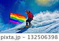 A person skiing down a snowy hill holding a rainbow flag 132506398