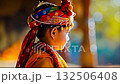 A small child wearing a colorful headdress and jewelry 132506408