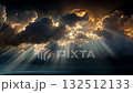 Dramatic sun rays shining through dark clouds over the ocean 132512133
