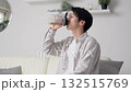 Asian man drinking protein in the living room 132515769