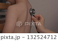 Examining a toddler's back with a stethoscope 1 132524712