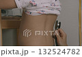 Examining a toddler's back with a stethoscope 2 132524782