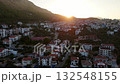 Aerial drone video of Kas town at sunrise with sunlight over hills, red rooftops, and calm morning atmosphere. Turkey 132548155