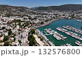 Aerial drone video of Bodrum marina in Turkey with white houses, yachts, and turquoise sea on a sunny summer day. 132576800