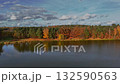 Autumn lake and colorful forest under a cloudy sky 132590563