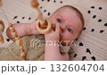 newborn baby plays with a wooden toy. Concept of Childhood, Parenthood. 132604704
