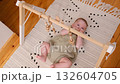 newborn baby plays with a wooden toy. Concept of Childhood, Parenthood. 132604705