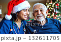 Smiling healthcare worker in festive attire shares joyful moment with elderly man, camera captures warmth and connection, gentle zoom in on expressions 132611705