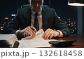 executive reviewing contracts at night, corporate auditor at desk with stacks of papers, lamp glow, calculator, city skyline through window, focused and methodical review of financial 132618458