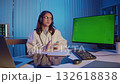 Female Doctor With Headset Sits at Desk in Evening Office, Ready to Present Medical Data on a Green Screen Monitor. Concept of Digital Healthcare, Online Training, and Modern Science Education. 132618838