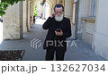 Elderly man resting and looking around in the city center 132627034