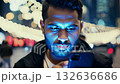 A person focused on his smartphone, illuminated by blue light in a lively urban setting at night. Colorful lights create a festive atmosphere around him 132636686