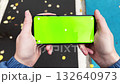 Handheld view of person walking and holding smartphone with green screen outdoors 132640973