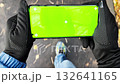Handheld view of person walking outdoors holding smartphone with green screen 132641165