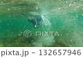 Snorkeler underwater with bubbles and flippers 132657946