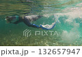 Snorkeler swimming underwater in clear ocean 132657947