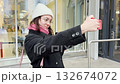 Portrait of a young woman using on a mobile phone. she make selfie outside on a cold winter day 132674072