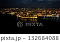 Night aerial flight orbiting in front of the illuminated historic center and port of Monopoli, Italy 132684088