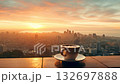 cup of hot espresso coffee or tea on table on illuminated city skyline background with skyscrapers, mug with drink at urban sunset night view on terrace 4k 132697888