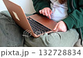 Smiling teenage student holding a laptop, standing against a clean white background, ready for school or study. 132728834
