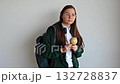 Smiling teenage student holding a globe, standing against a clean white background, ready for school or study. 132728837