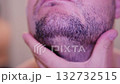 Close-up footage of a man examining his stubble with his hands before shaving. 132732515