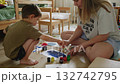 Mother and son painting together on floor 132742795