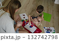 Mother and son painting together on floor 132742798