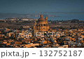 Malta, Comino island: The Church of Saint John the Baptist, known as Xewkija Rotunda majestically rising in the heart of Gharb. Gozo. Village city basks in warm glow of sunset. Drone flight footage Malta, Comino island: The Church of Saint John the Baptist, known as Xewkija Rotunda majestically rising in the heart of Gharb. Gozo. Village city basks in warm glow of sunset. Drone flight footage 132752187