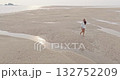 Woman enjoying leisurely barefoot walk on vast sandy beach at low tide, explore receding waters and textured patterns under the warm sunlight during a relaxing ocean vacation. Aerial drone flight Woman enjoying leisurely barefoot walk on vast sandy beach at low tide, explore receding waters and textured patterns under the warm sunlight during a relaxing ocean vacation. Aerial drone flight 132752209