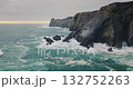 Portugal, Lisbon: dramatic Praia da Adraga beach coast showing powerful ocean waves crashing against dark, rugged cliffs and rocky formations, creating a moody coastal seascape. Aerial drone flight Portugal, Lisbon: dramatic Praia da Adraga beach coast showing powerful ocean waves crashing against dark, rugged cliffs and rocky formations, creating a moody coastal seascape. Aerial drone flight 132752263