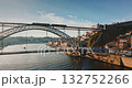 Portugal: Dom Luis I Bridge spans Douro River in Porto, with commuter train on upper deck and traffic below, framed by historic riverfront buildings at golden sunset hour. Aerial view drone footage Portugal: Dom Luis I Bridge spans Douro River in Porto, with commuter train on upper deck and traffic below, framed by historic riverfront buildings at golden sunset hour. Aerial view drone footage 132752266