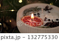 decorative christmas candle with orange and spices extinguishing. closeup. 132775330