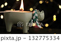 lighting cat shaped candle with match for cozy atmosphere. closeup. 132775334