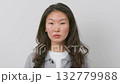 Portrait of a young woman with natural expression on plain background.  132779988