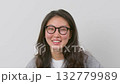 Portrait of smiling woman with glasses and long hair on light background.  132779989