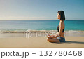 A woman meditating on a tropical beach - a peaceful retreat 132780468