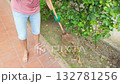 Man cleaning garden with rake and gloves 132781256