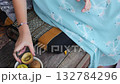 Preteen Girl Eating Kiwi on Wooden Bench in Rural Setting 132784296