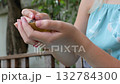 Preteen Girl Scooping and Eating Kiwi with Spoon Outdoors 132784300