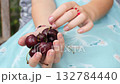 Preteen Girl in Blue Dress Eating Large Cherries Outdoors 132784440