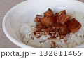 Stirring and pouring braised pork belly meat over cooked rice. 132811465