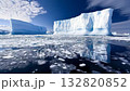 Icebergs tower dramatically above a pristine, icy expanse, reflecting subtle hues while the sky casts a soft light during the tranquil day 132820852