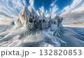 Icebergs tower dramatically above a pristine, icy expanse, reflecting subtle hues while the sky casts a soft light during the tranquil day 132820853