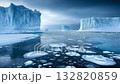 Icebergs tower dramatically above a pristine, icy expanse, reflecting subtle hues while the sky casts a soft light during the tranquil day 132820859