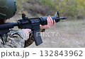 Soldier in tactical gear aims a rifle. 132843962
