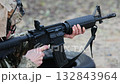 Soldier in tactical gear aims a rifle. Concept for modern warfare, security operations, and disciplined focus 132843964