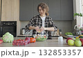 Woman Squeezing Lemon Juice On Fresh Vegetable Salad In Modern Kitchen 132853357